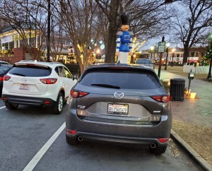 Two generations of Mazda CX5 parked by a tall Christmas Nutcracker in Marietta GA