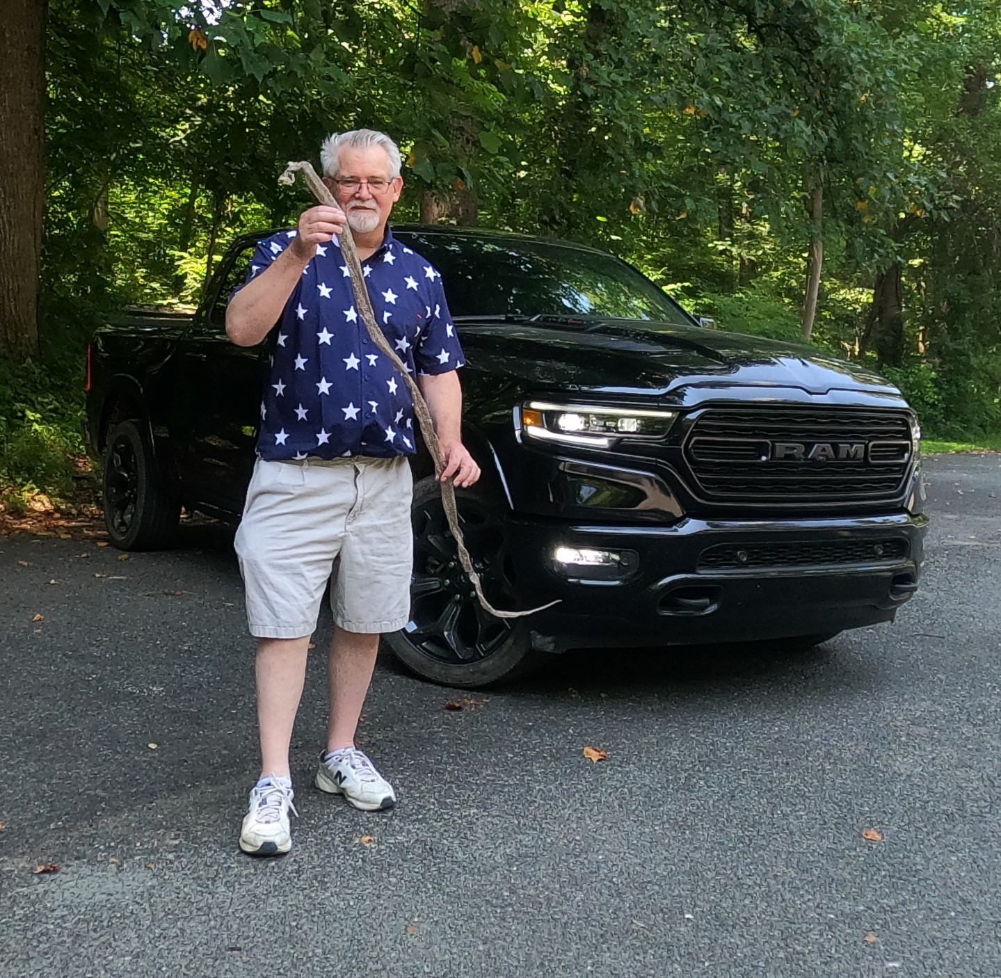 william west hopper holding a snakeskin in front of a 2020 ram 1500 limited crew cab 4x4
