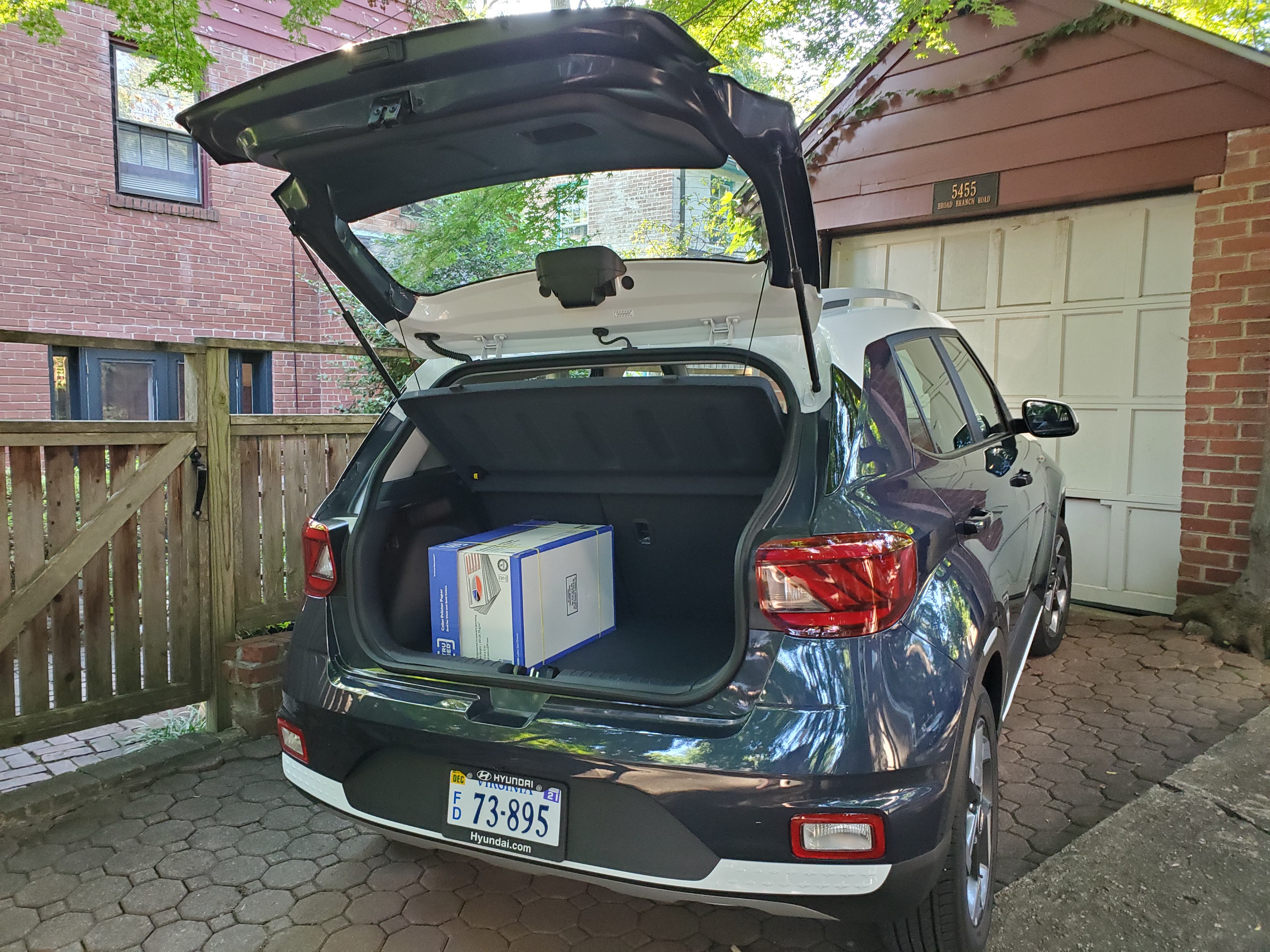 the rear hatch of the 2021 hyundai venue open with a case of paper in the cargo hold