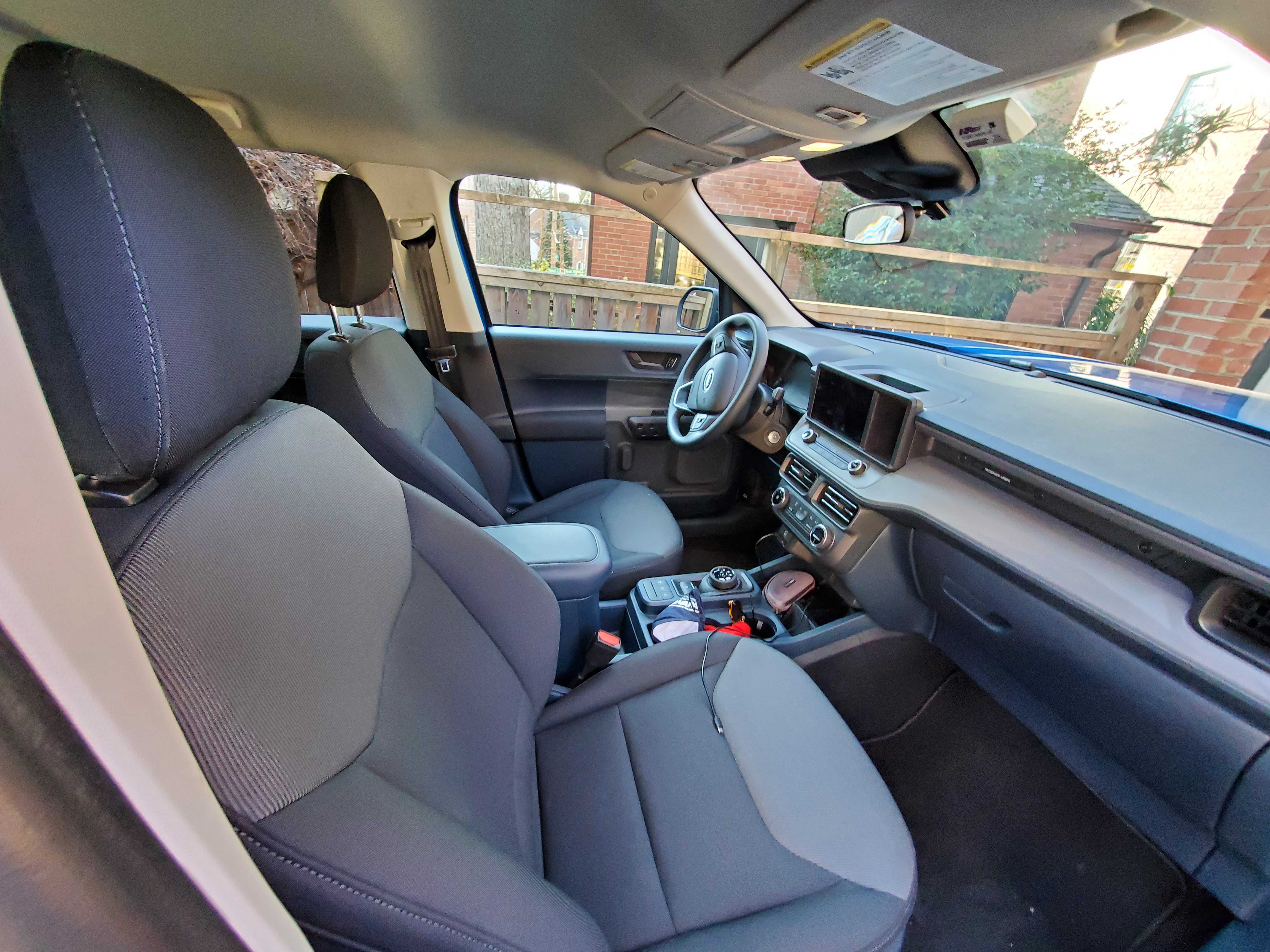 The front seats of the Ford Maverick XL a base model are covered in cloth. Clean and functional interior design.