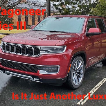 Red 2022 Wagoneer parked in front of split rail fence