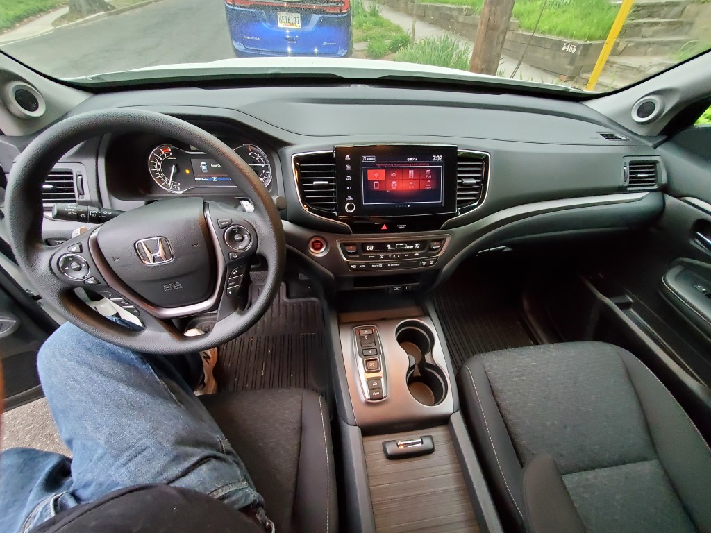 Ridgeline has a functional interior with durable seat fabric and plenty of storage space. Note the pushbutton transmission selector.